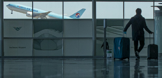 국내에서 코로나19 첫 확진자가 발생한 지 1년을 하루 앞둔 19일 오전 인천국제공항 제2터미널 출국장 창문 너머로 비행기가 이륙하고 있다.  연합뉴스